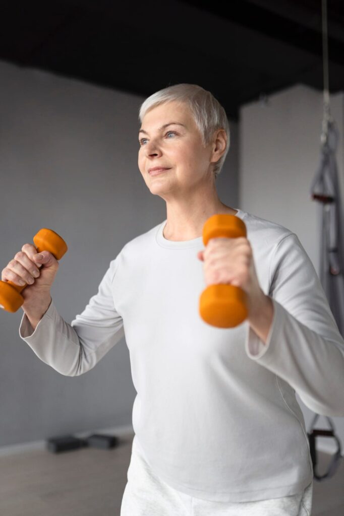 Woman over 60 doing light dumbbell exercise for healthy aging.