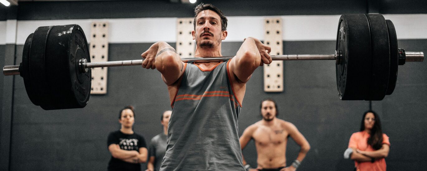 A lifter executing a compound movement in a gym setting to start a 3-day compound lifting workout routine