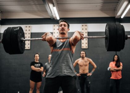 A lifter executing a compound movement in a gym setting to start a 3-day compound lifting workout routine