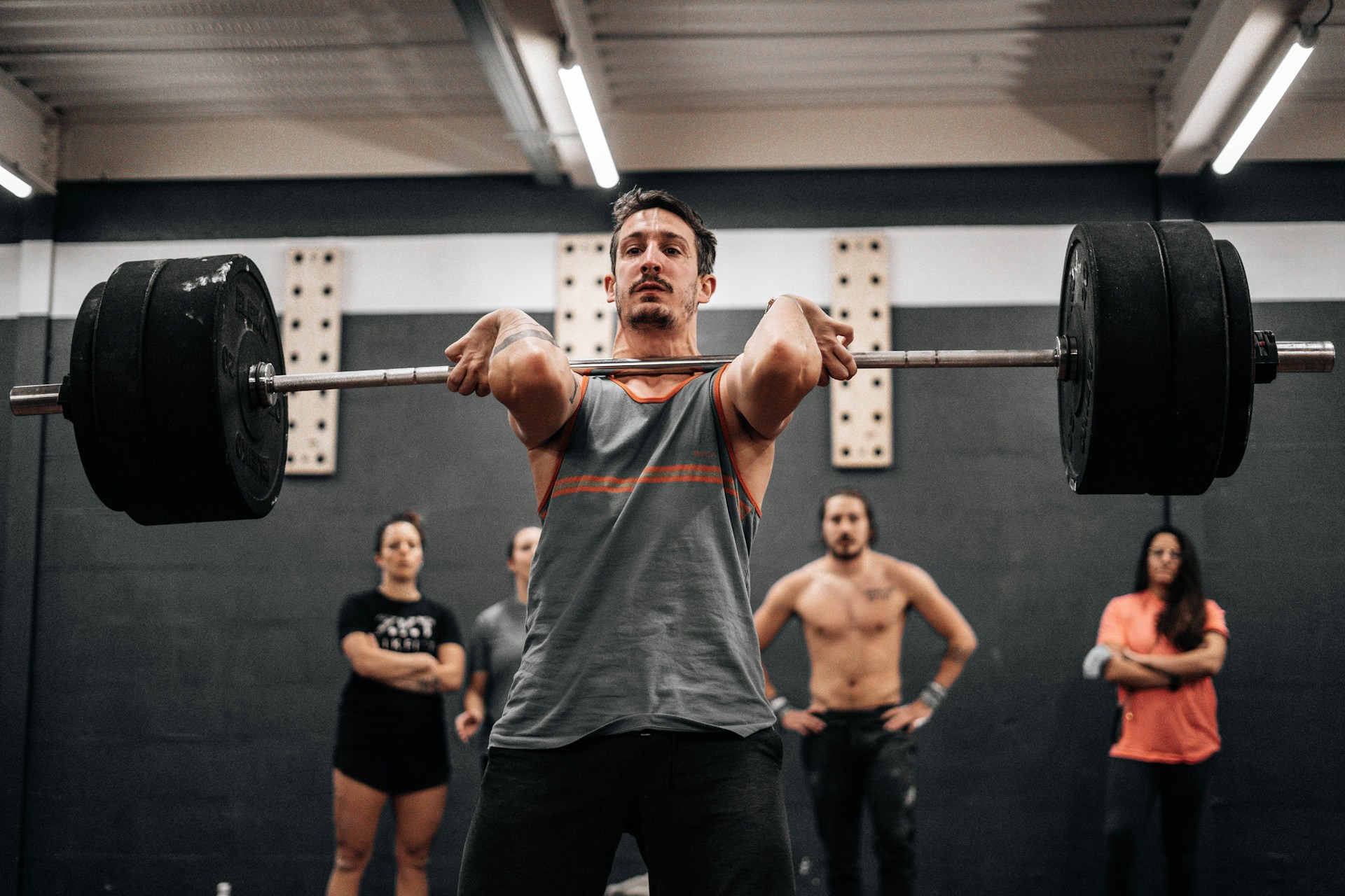 A lifter executing a compound movement in a gym setting to start a 3-day compound lifting workout routine