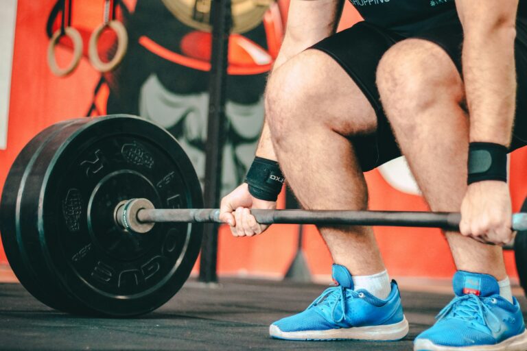 Close up of a deadlift setup demonstrating a compound lifting workout routine to maximize glucose uptake