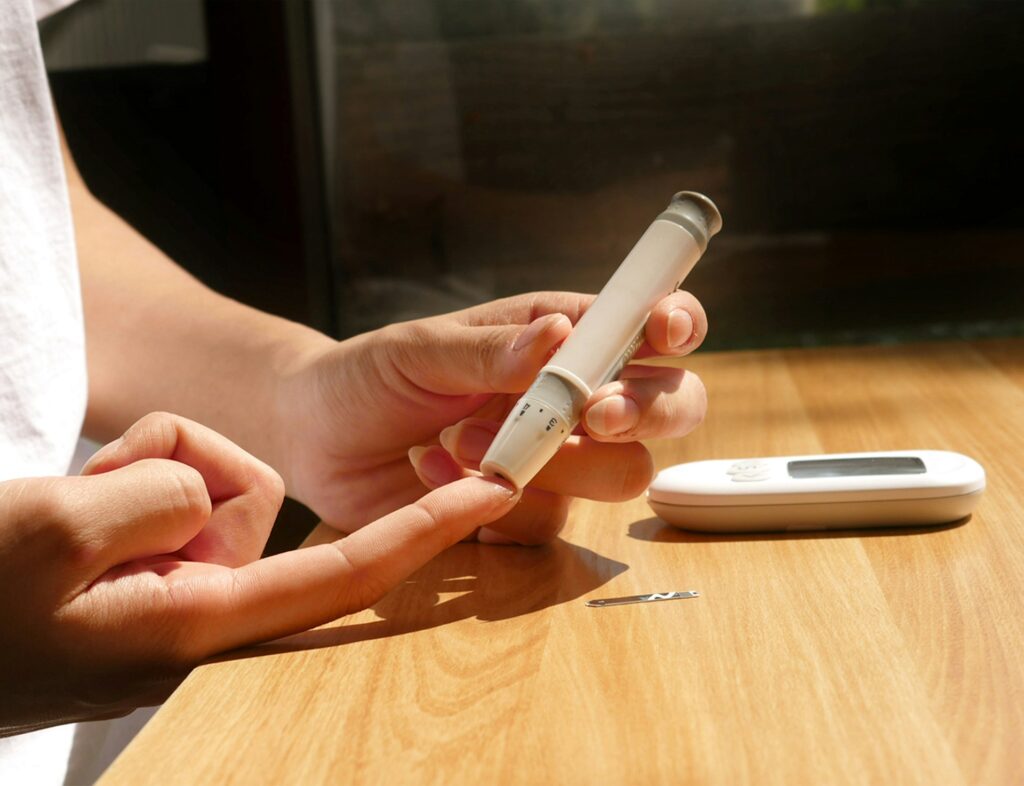 Person checking blood sugar for warning signs of insulin resistance