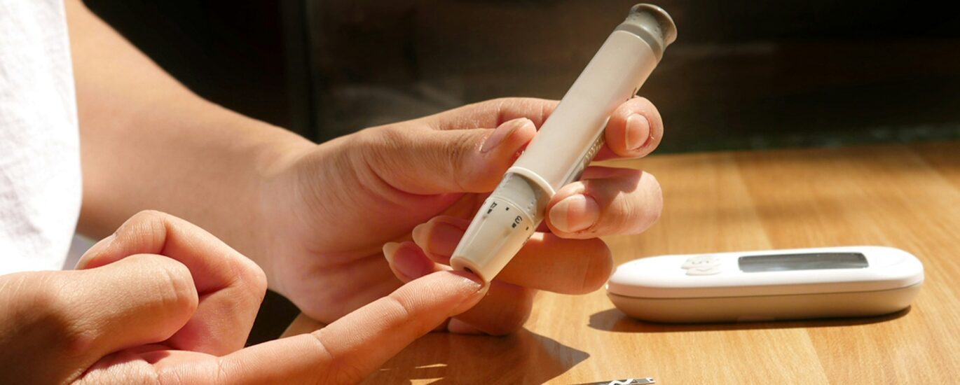 Person checking blood sugar for warning signs of insulin resistance