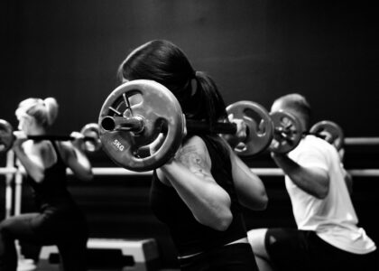 Group class doing weighted barbell squats for bone health after 40
