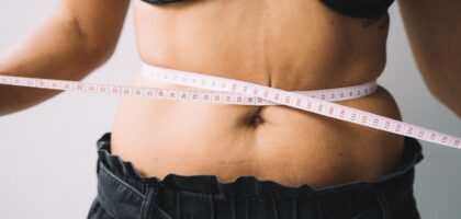 Woman measuring stress belly fat around midsection