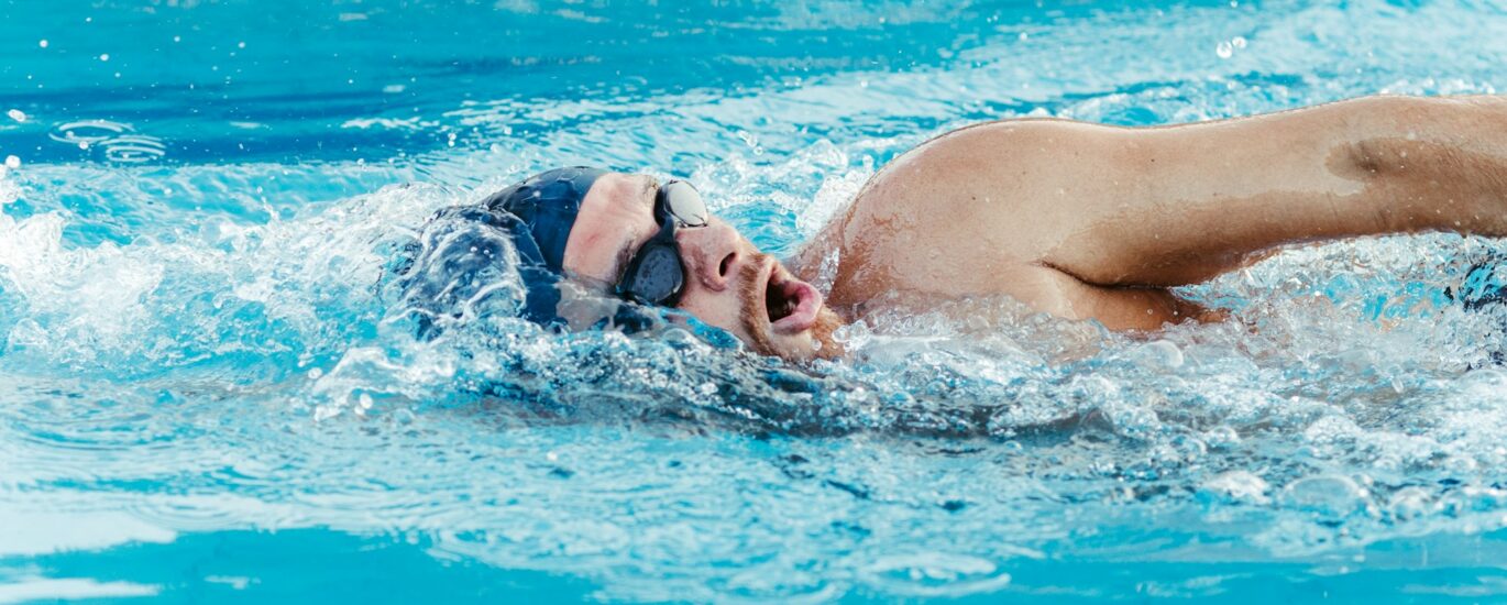 Adult swimmer practicing freestyle lap swimming for longevity in a pool