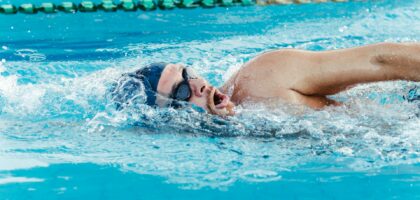 Adult swimmer practicing freestyle lap swimming for longevity in a pool
